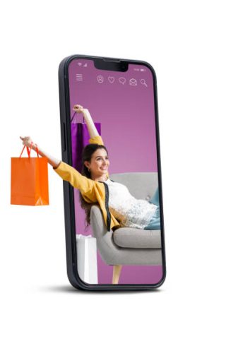 Happy fashionable young woman sitting and holding shopping bags in a smartphone, she is doing online shopping, blank copy space